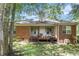 A cozy backyard with a brick home, a deck, and natural landscaping at 6718 Oakhurst Ct, Douglasville, GA 30134