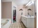 Well-lit bathroom with a double vanity, soaking tub, and walk-in closet at 6718 Oakhurst Ct, Douglasville, GA 30134