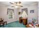 This bedroom is designed for hobbies with a ceiling fan and bright floral curtains at 6718 Oakhurst Ct, Douglasville, GA 30134