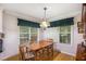 Cozy dining area features hardwood floors, a wooden table, and natural light from curtained windows at 6718 Oakhurst Ct, Douglasville, GA 30134