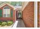 Inviting front entrance featuring a glass-paneled door and green shutters on the surrounding windows at 6718 Oakhurst Ct, Douglasville, GA 30134