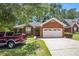 Charming brick home with a two-car garage and a well-maintained front yard and a red pickup truck at 6718 Oakhurst Ct, Douglasville, GA 30134