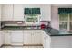 Functional kitchen with white cabinets, green countertops, and a double basin sink under a window at 6718 Oakhurst Ct, Douglasville, GA 30134