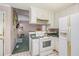 Kitchen with white appliances and a view into the living room with a fireplace at 6718 Oakhurst Ct, Douglasville, GA 30134