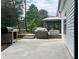 Backyard concrete patio with a grill, smoker, hot tub, and a gazebo next to the house at 6940 Treeline Dr, Cumming, GA 30028