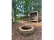 Backyard with a fire pit surrounded by trees and a place to store wood at 6940 Treeline Dr, Cumming, GA 30028