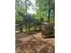 Backyard with fire pit and wood storage area surrounded by mature trees at 6940 Treeline Dr, Cumming, GA 30028