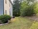 Backyard with a grassy area, landscaping, and wooded view providing privacy and space at 6940 Treeline Dr, Cumming, GA 30028