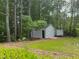 An outdoor storage shed sits on a verdant lawn surrounded by mature trees at 6940 Treeline Dr, Cumming, GA 30028