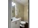 Well-lit half bath with neutral paint, white cabinets, and dark hardwood floors at 6940 Treeline Dr, Cumming, GA 30028