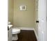 Cozy half bath with neutral paint, white cabinets, and dark hardwood floors at 6940 Treeline Dr, Cumming, GA 30028