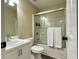 Bright bathroom featuring a shower-tub combo with glass doors and a white single sink vanity at 6940 Treeline Dr, Cumming, GA 30028
