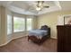 Bright bedroom with a tray ceiling, ceiling fan, and large windows at 6940 Treeline Dr, Cumming, GA 30028