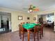 Game room with a multi-colored ceiling fan and a wooden game table and view into entry and dining room at 6940 Treeline Dr, Cumming, GA 30028