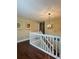 Upper landing with railing, modern light fixture, hardwood floors, and artwork at 6940 Treeline Dr, Cumming, GA 30028