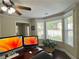 Well-lit home office featuring hardwood floors, a ceiling fan, and a large bay window at 6940 Treeline Dr, Cumming, GA 30028