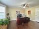 Home office featuring hardwood floors, a ceiling fan, and a large desk with dual computer monitors at 6940 Treeline Dr, Cumming, GA 30028