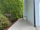 Exterior shot showcasing a side yard with a patio and lush greenery. Great for curb appeal at 6940 Treeline Dr, Cumming, GA 30028