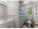 Cozy bathroom with a toilet, sink, mirror and shower with striped curtain at 1172 Malvern Hunt Ct, Lawrenceville, GA 30043
