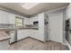 Well-lit kitchen featuring white cabinetry, stainless steel appliances, and durable flooring at 1172 Malvern Hunt Ct, Lawrenceville, GA 30043