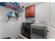 Functional laundry room equipped with modern front-load washer and dryer, storage cabinets, and shelving for supplies at 1172 Malvern Hunt Ct, Lawrenceville, GA 30043