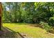 A well-maintained backyard lawn is surrounded by mature trees offering a lush, private outdoor space at 131 Lively St, Norcross, GA 30071