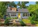 Charming home featuring a landscaped front yard with garden beds and a bright yellow front door at 131 Lively St, Norcross, GA 30071