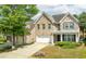 Two story home with brick and siding, featuring a manicured lawn and driveway leading to the 2-car garage at 1310 Scenic View Trce, Lawrenceville, GA 30044