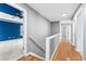 Upstairs hallway with hardwood floors leads to bedroom with blue accent wall and multiple doorways at 1310 Scenic View Trce, Lawrenceville, GA 30044