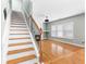 Inviting living room featuring hardwood floors, fireplace, and staircase with white risers and dark wood treads at 1310 Scenic View Trce, Lawrenceville, GA 30044