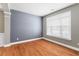 An empty room with hardwood floors, grey walls, white trim, and a large window at 1310 Scenic View Trce, Lawrenceville, GA 30044