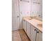 Bathroom with a double vanity featuring white cabinets, tile floors, and modern fixtures at 4503 Hunters Ter, Stone Mountain, GA 30083