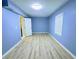 Bedroom with wood-look floors, light blue painted walls, natural light, and a closet at 4503 Hunters Ter, Stone Mountain, GA 30083