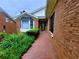 A red brick walkway leads to the home's entrance near a manicured yard and brick exterior at 4503 Hunters Ter, Stone Mountain, GA 30083