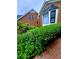 Close-up shot of the landscaped front yard with healthy green bushes and flowers near the brick exterior at 4503 Hunters Ter, Stone Mountain, GA 30083
