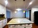 Kitchen island with granite countertop and pendant lighting, open to the living and dining spaces at 4503 Hunters Ter, Stone Mountain, GA 30083