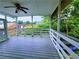 Relaxing covered porch featuring wooden deck, white railings, and a ceiling fan at 4503 Hunters Ter, Stone Mountain, GA 30083