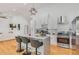 Stylish kitchen featuring an island with seating, stainless steel appliances, white cabinetry, and a modern range hood at 1497 Eason Nw St, Atlanta, GA 30314