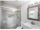 Elegant bathroom featuring a tiled shower with a glass door, modern fixtures, and a stylish vanity mirror at 2100 Rockies Ct, Norcross, GA 30071
