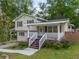 Charming two-story home featuring a welcoming front porch with red accents and blossoming roses at 2100 Rockies Ct, Norcross, GA 30071