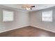 Bedroom with wood floors, grey paint, white crown molding, ceiling fan and two windows at 3600 Anglin Rd, Loganville, GA 30052