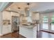 Bright kitchen features stainless appliances, granite countertops and island with cooktop, and access to the outdoor deck at 3600 Anglin Rd, Loganville, GA 30052