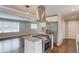 Open kitchen layout with stainless appliances, granite countertops and island with cooktop, and hardwood floors at 3600 Anglin Rd, Loganville, GA 30052