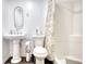 Cozy bathroom features pedestal sink, toilet, and shower with decorative curtain at 4180 Mount Paran Dr, Social Circle, GA 30025