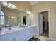 Bright bathroom features double vanity, large mirror, and walk-in shower; open doorway to walk-in closet at 4180 Mount Paran Dr, Social Circle, GA 30025