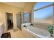 Luxurious main bathroom featuring a soaking tub, a separate glass shower, and abundant natural light, perfect for relaxation at 4180 Mount Paran Dr, Social Circle, GA 30025