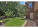 Well-maintained backyard with a grassy area, landscaping, and access to the home at 1136 Garner Creek At Parkview Sw Dr, Lilburn, GA 30047