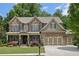 Beautiful two-story brick home with lush landscaping, a welcoming front porch, and three-car garage at 1136 Garner Creek At Parkview Sw Dr, Lilburn, GA 30047
