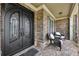 Inviting front porch with elegant double doors, brickwork, and seating area at 1136 Garner Creek At Parkview Sw Dr, Lilburn, GA 30047
