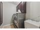 Convenient laundry room features a washer, dryer, utility sink, and cabinetry at 1136 Garner Creek At Parkview Sw Dr, Lilburn, GA 30047